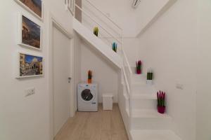 a washing machine in a white room with stairs at Stone House Michelle in Torre Annunziata