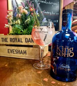 una bottiglia di vino seduta accanto a un bicchiere di vino di The Royal Oak a Evesham