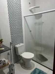 a bathroom with a toilet and a glass shower at Chalé Ipê Branco in Pedra Azul