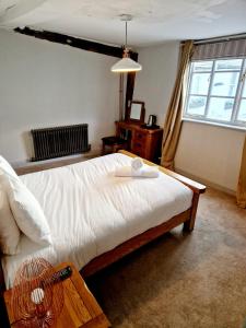 a bedroom with a bed with a fan and a window at The Royal Oak in Evesham