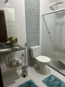 a bathroom with a toilet and a glass shower at Chalé Ipê Branco in Pedra Azul