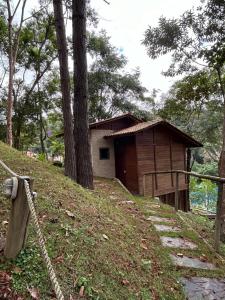 a small wooden building on a hill with trees at Chalé Ipê Branco in Pedra Azul