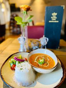 um prato com uma tigela de sopa e arroz numa mesa em The Royal Oak em Evesham