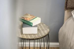 twee boeken op een tafel naast een bed bij Cucchiari Suite 2 Tipo in Modena