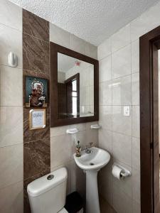 a bathroom with a sink and a toilet and a mirror at Mamitas House! Mini Suit Privada Junto al Metro de Quito in Quito