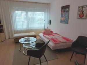 Habitación con cama, mesa y sillas. en Apartment-Ferienwohnung in Mainaschaff, en Mainaschaff