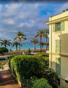 a building with a view of the ocean and palm trees at Hotel Flots d'Azur in Nice