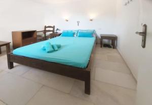 een bed met blauwe lakens en blauwe kussens in een kamer bij Teal Blue Serenity in Agiassos