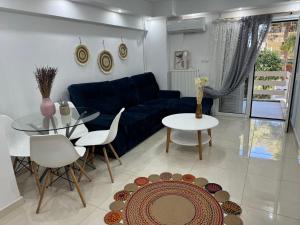 sala de estar con sofá azul y mesa de cristal en Luxury Varkiza Apartment, en Varkiza