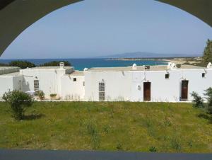een wit huis op een heuvel met de oceaan op de achtergrond bij Teal Blue Serenity in Agiassos