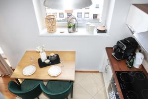 una pequeña cocina con mesa de madera y sillas en Apartament Kokpit en Piła