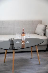 a table with a bottle of wine and wine glasses at Celia Residence in Athens
