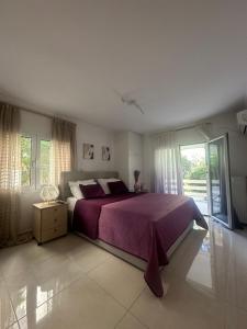 1 dormitorio con 1 cama con colcha púrpura en Luxury Varkiza Apartment, en Varkiza