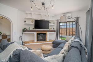 a living room with a blue couch and a fireplace at Host Wise - Sunny Spacious House - Terrace & Free Parking in Lagoa
