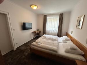 ein Hotelzimmer mit einem Bett und einem TV in der Unterkunft Pension Baranekhof - accommodation in nature - Baranek Resorts in Kaprun