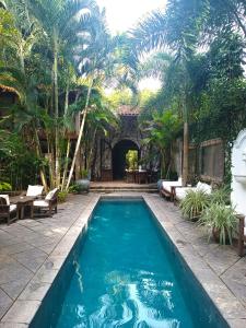 a swimming pool in a resort with palm trees at Monkey Casa Hotel in Trancoso