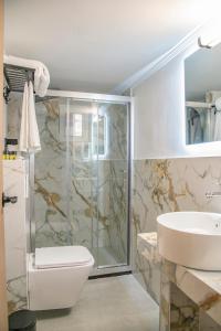 y baño con ducha, aseo y lavamanos. en Celia Residence, en Atenas