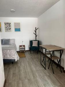 1 dormitorio con cama, escritorio y mesa en Mamitas House! Mini Suit Privada Junto al Metro de Quito, en Quito