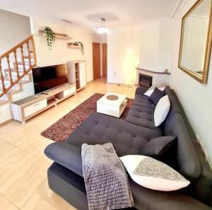 sala de estar con sofá y TV en Casa en Punta Prima, en Alicante