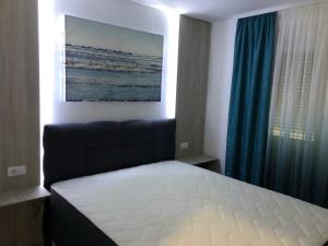 a bedroom with a bed and a blue curtain at Romantika 3 in Ostrovo