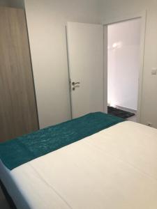 een slaapkamer met een wit bed en een deur bij Romantika 3 in Ostrovo
