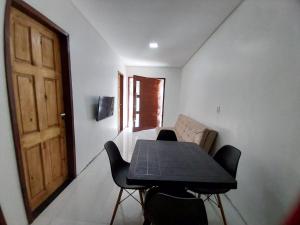 uma mesa e cadeiras num quarto com uma porta em Casa Pitanga em Olinda