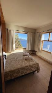 a bedroom with a bed with a view of the ocean at Las Gaviotas in San Carlos de Bariloche