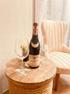 a bottle of wine and two glasses on a table at Ca' Balenga - Cozy Stay in the Old Town with Free Private Parking in Asti