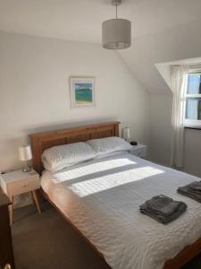 a bedroom with a large bed with white sheets at Courtyard Cottage - Grade II listed - Barnstaple in Barnstaple