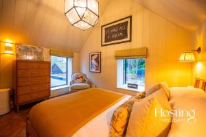 Schlafzimmer mit einem Bett, einer Kommode und Fenstern in der Unterkunft The Writers Retreat in Medmenham