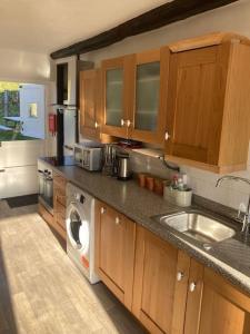 a kitchen with a sink and a washing machine at Courtyard Cottage - Grade II listed - Barnstaple in Barnstaple