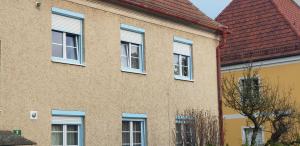 ein Gebäude mit blauen Fenstern und einem roten Dach in der Unterkunft Ferienwohnung Borse in Langenlois