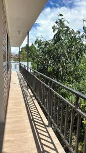 a porch of a house with a fence and trees at La Herencia - Oxapampa in Oxapampa
