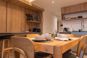 cocina con mesa de madera y sillas en Lake Inn - Departamentos con costa de Lago en San Carlos de Bariloche