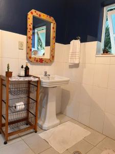 a bathroom with a sink and a mirror at Seu Refúgio com Lareira Próximo ao Petar in Apiaí