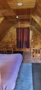 - une chambre avec un lit et une fenêtre dans une cabine dans l'établissement Forest View Cottage, à Jibhi