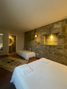 a bedroom with two beds and a stone wall at MaSaLa Otel in Alacati