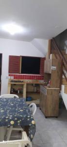 einen Tisch und Stühle in einem Zimmer mit TV in der Unterkunft COMPLEJO PONTA das BRILLES DUPLEX in Nísia Floresta