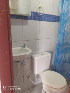 a bathroom with a toilet and a sink at COMPLEJO PONTA das BRILLES DUPLEX in Nísia Floresta