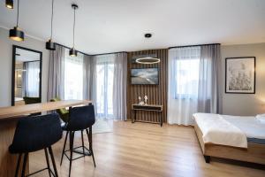 Apartamenty i Pokoje Złote Piaski في ياستراوبيا جورا: غرفة نوم بسرير وطاولة وكراسي