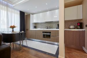 a kitchen with a table and a kitchen with white cabinets at The Queen Luxury Apartments - Villa Medici in Luxembourg