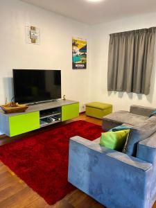 Apartment Heitiare في بابيت: غرفة معيشة مع تلفزيون بشاشة مسطحة وأريكة