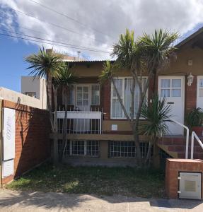 ein Haus mit Palmen davor in der Unterkunft Mamama’s House in Puerto Madryn