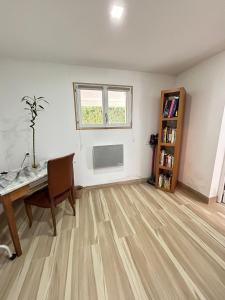 an empty living room with a table and a book shelf at Les Bambous in Poissy