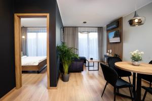 加茨比亚格拉Apartamenty i Pokoje Złote Piaski的一间带餐桌的客厅和一间卧室