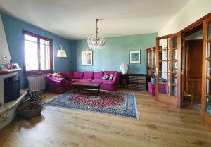 uma sala de estar com um sofá rosa e uma mesa em Casa di Laura in Chianti - large & charming house (host 7 people) em Moncioni
