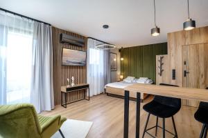 Apartamenty i Pokoje Złote Piaski في ياستراوبيا جورا: غرفة نوم بسرير وطاولة في غرفة