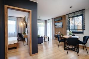 加茨比亚格拉Apartamenty i Pokoje Złote Piaski的公寓设有用餐室和卧室。