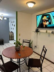 een kamer met een tafel en een tv aan de muur bij Caza en zona residencial in Uruapan del Progreso