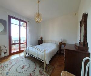 um quarto com uma cama, uma janela e um lustre em Casa di Laura in Chianti - large & charming house (host 7 people) em Moncioni